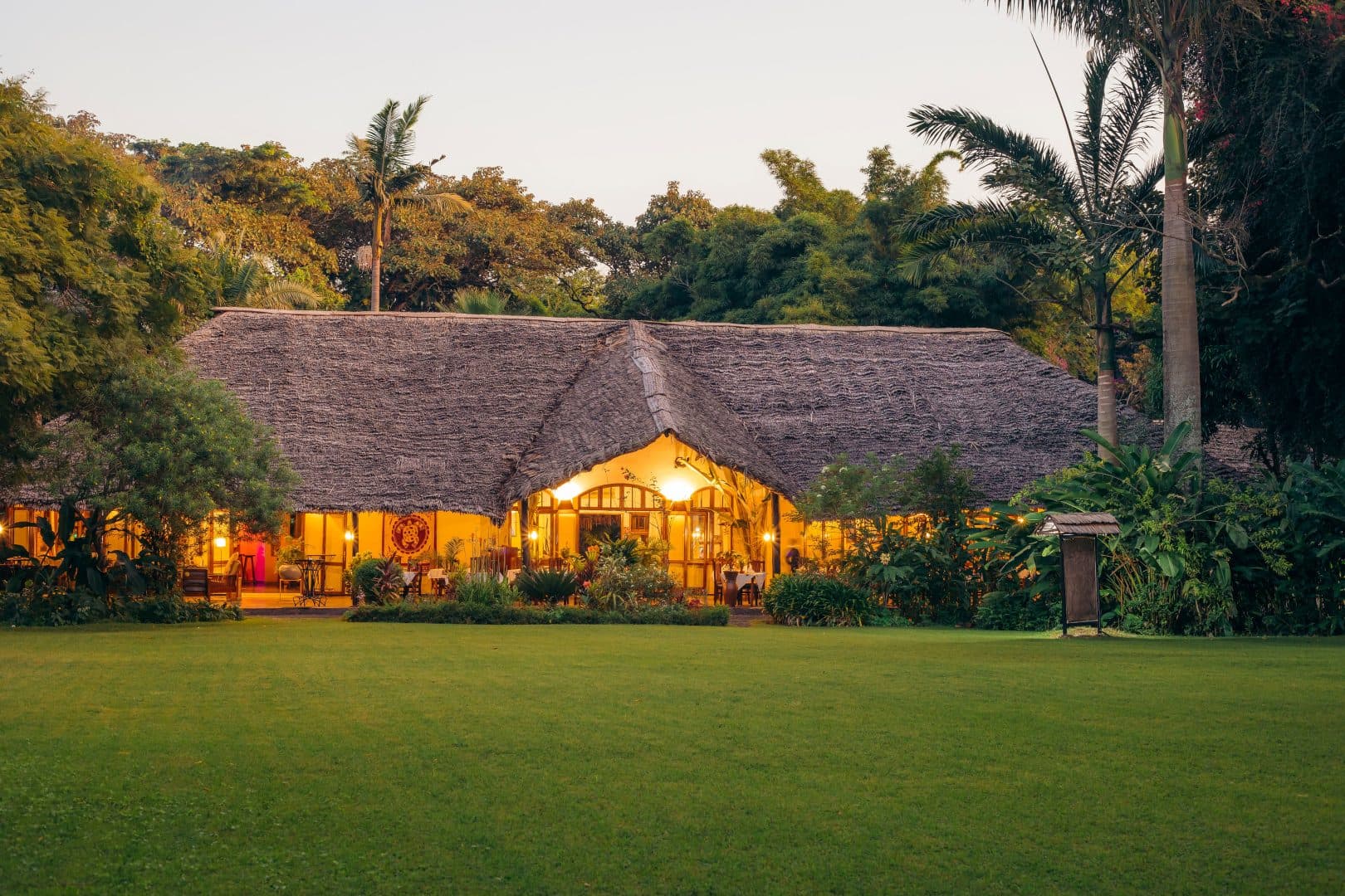 Lodge au toit de chaume dans un jardin tropical